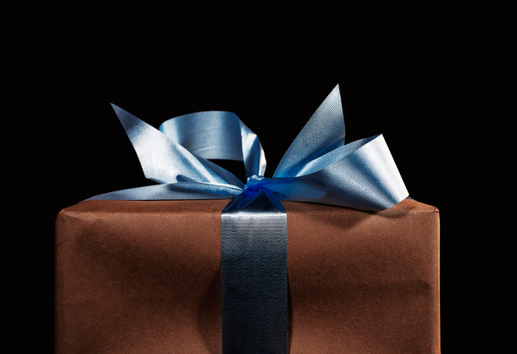 Elegant verpacktes Geschenk mit blauem Satinband – besondere Geschenkideen für Frauen mit Bedeutung