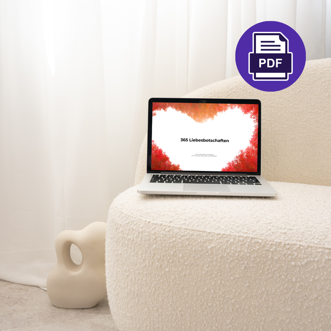 Digitales Mockup des PDF „365 Liebesbotschaften“ auf einem Laptop, der auf einem cremefarbenen Sessel steht, mit rotem Herz-Motiv auf dem Bildschirm.