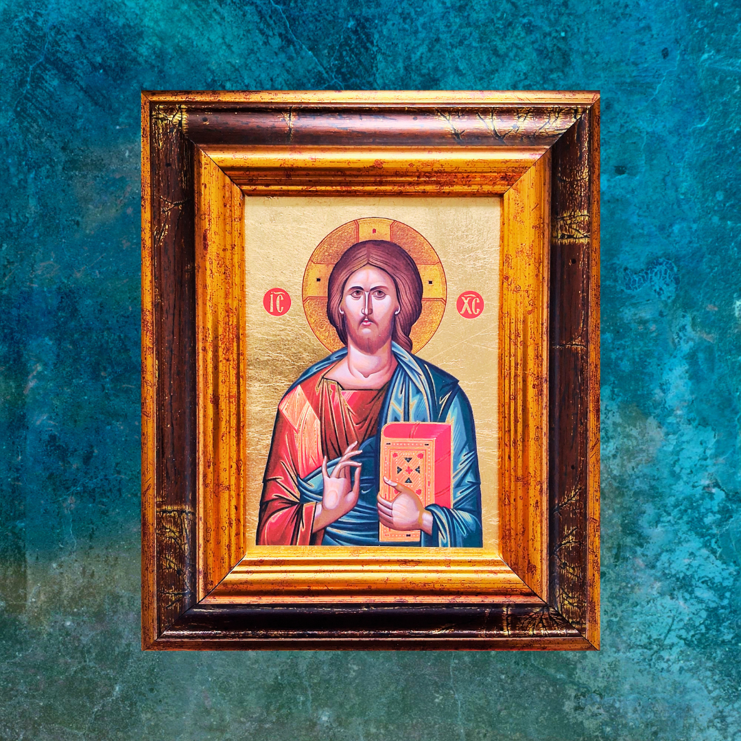Ikone Christus Pantokrator im verzierten Holzrahmen vor blau-grünem Hintergrund.