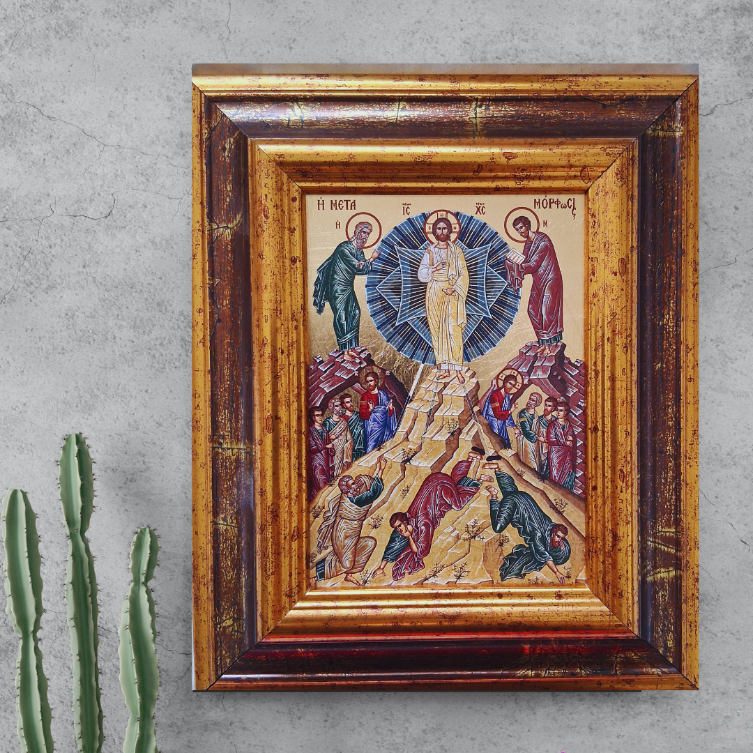 Ikone „Die Verklärung Christi auf dem Berg Tabor“ im verzierten Holzrahmen vor grauer Wand mit Kaktuspflanze.