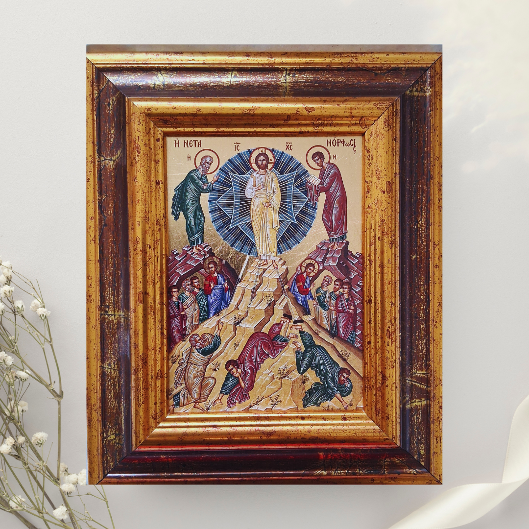 Ikone „Die Verklärung Christi auf dem Berg Tabor“ im verzierten Holzrahmen vor weißem Hintergrund mit Blütenzweig.