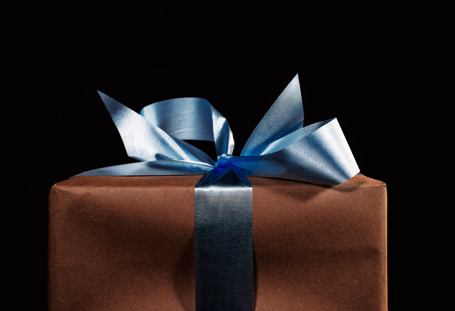 Elegant verpacktes Geschenk mit blauem Satinband – besondere Geschenkideen für Frauen mit Bedeutung
